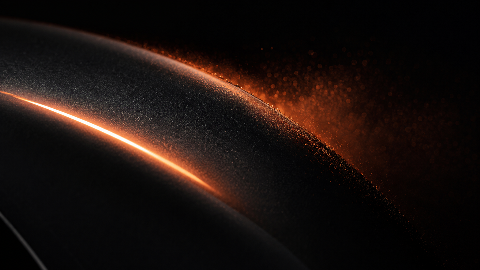 Macro of a mirror-gloss anthracite clearcoat with controlled overspray fading into darkness